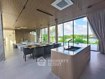 Luxurious open-plan living room with stunning lake view and modern kitchen island.