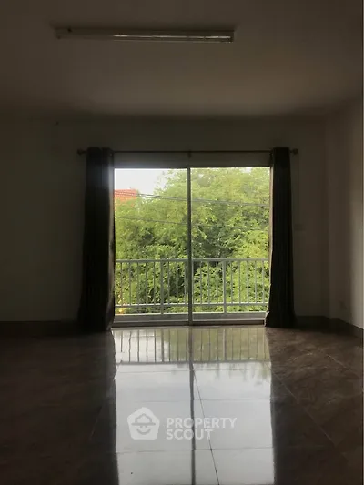 Spacious room with large window and lush green view, perfect for natural light lovers.