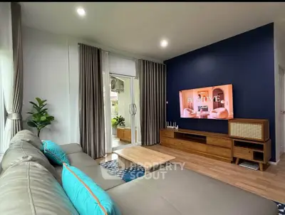 Stylish living room with modern decor and large TV, perfect for relaxation.
