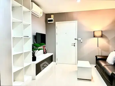 Modern living room with sleek furniture and bright lighting, featuring a stylish TV unit and cozy ambiance.