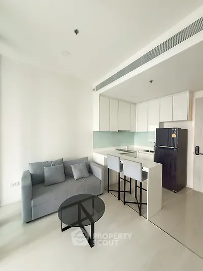 Modern open-layout living room with sleek kitchen and stylish furniture