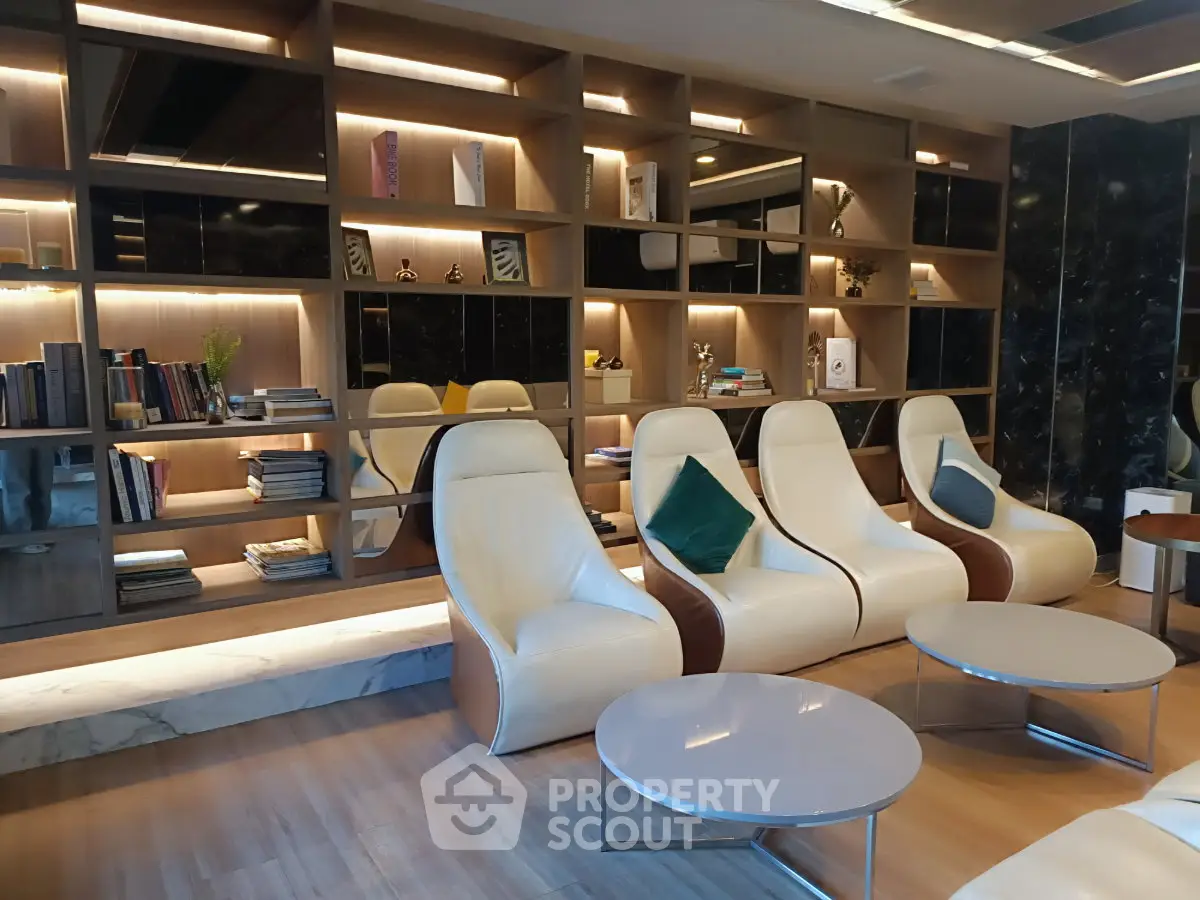 Luxurious modern lounge with sleek leather chairs and stylish shelving, perfect for relaxation and social gatherings.