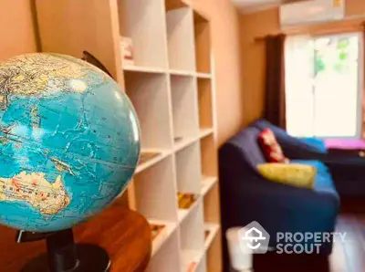 Cozy living room with globe and bookshelf, perfect for relaxation.