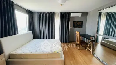 Spacious bedroom with large windows and modern furnishings in a stylish apartment.
