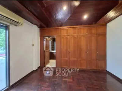 Spacious bedroom with wooden flooring and built-in wardrobe, perfect for cozy living.