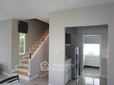 Modern home interior with sleek kitchen and stylish staircase design.