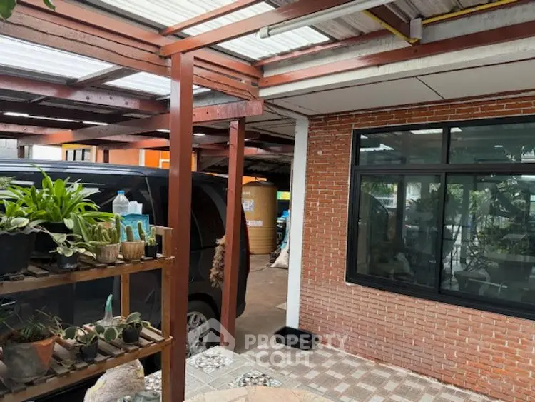 Charming covered parking area with brick wall and lush plants