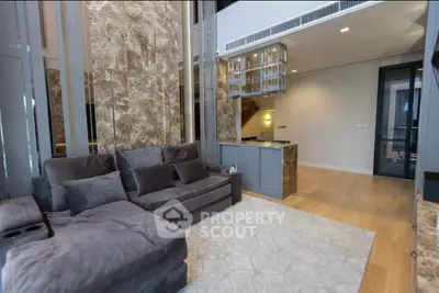 Luxurious modern living room with plush gray sofa and elegant marble accents