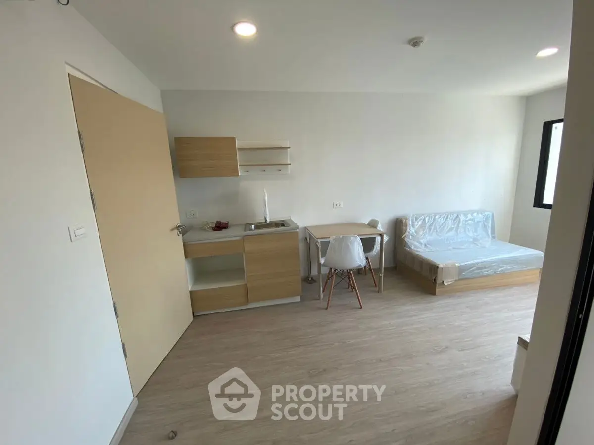 Modern studio apartment with compact kitchen and cozy living area