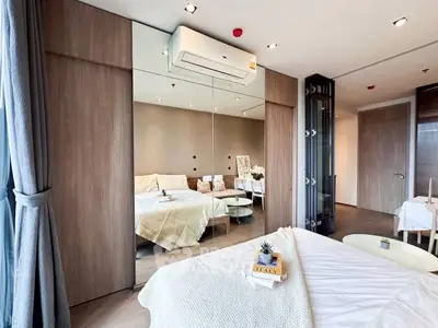 Modern bedroom with mirrored wall and cozy decor in stylish apartment