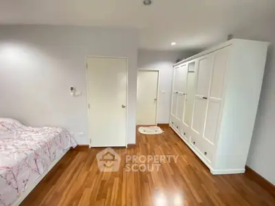 Spacious bedroom with elegant wooden flooring and ample wardrobe space