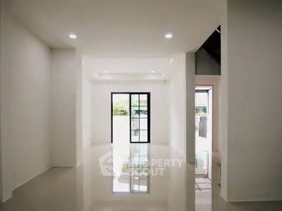 Spacious modern living room with glossy tiled floors and large windows for natural light.