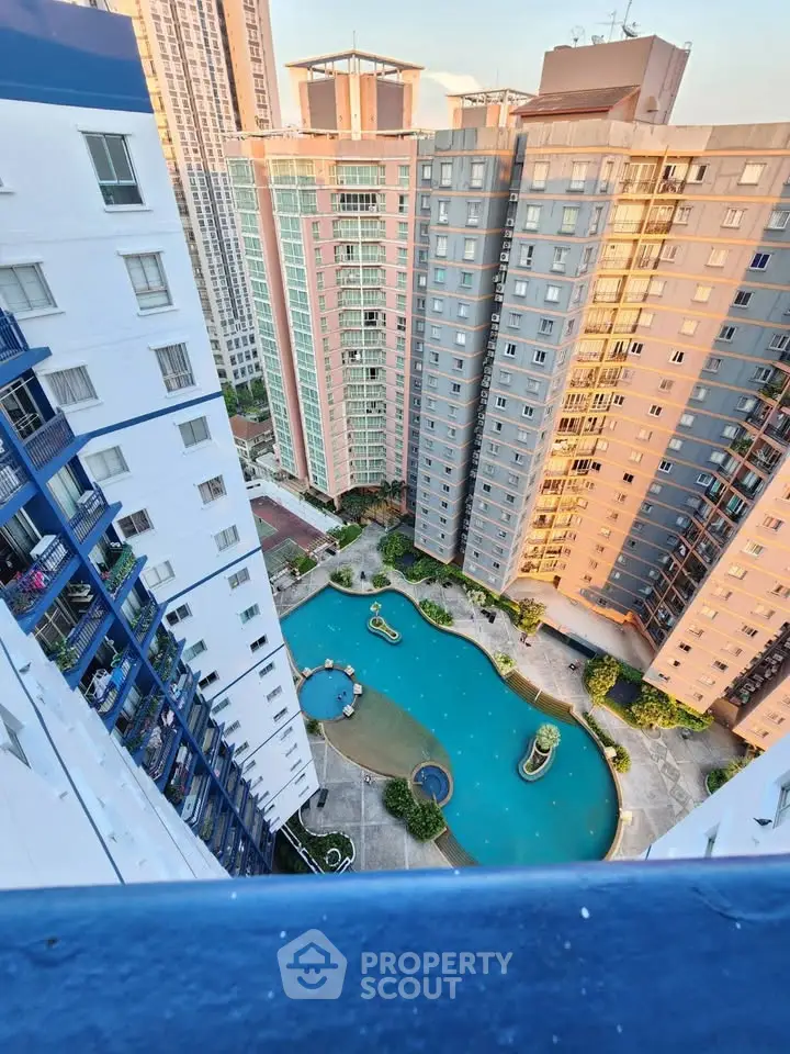Stunning aerial view of modern high-rise buildings with a luxurious pool area, perfect for urban living.