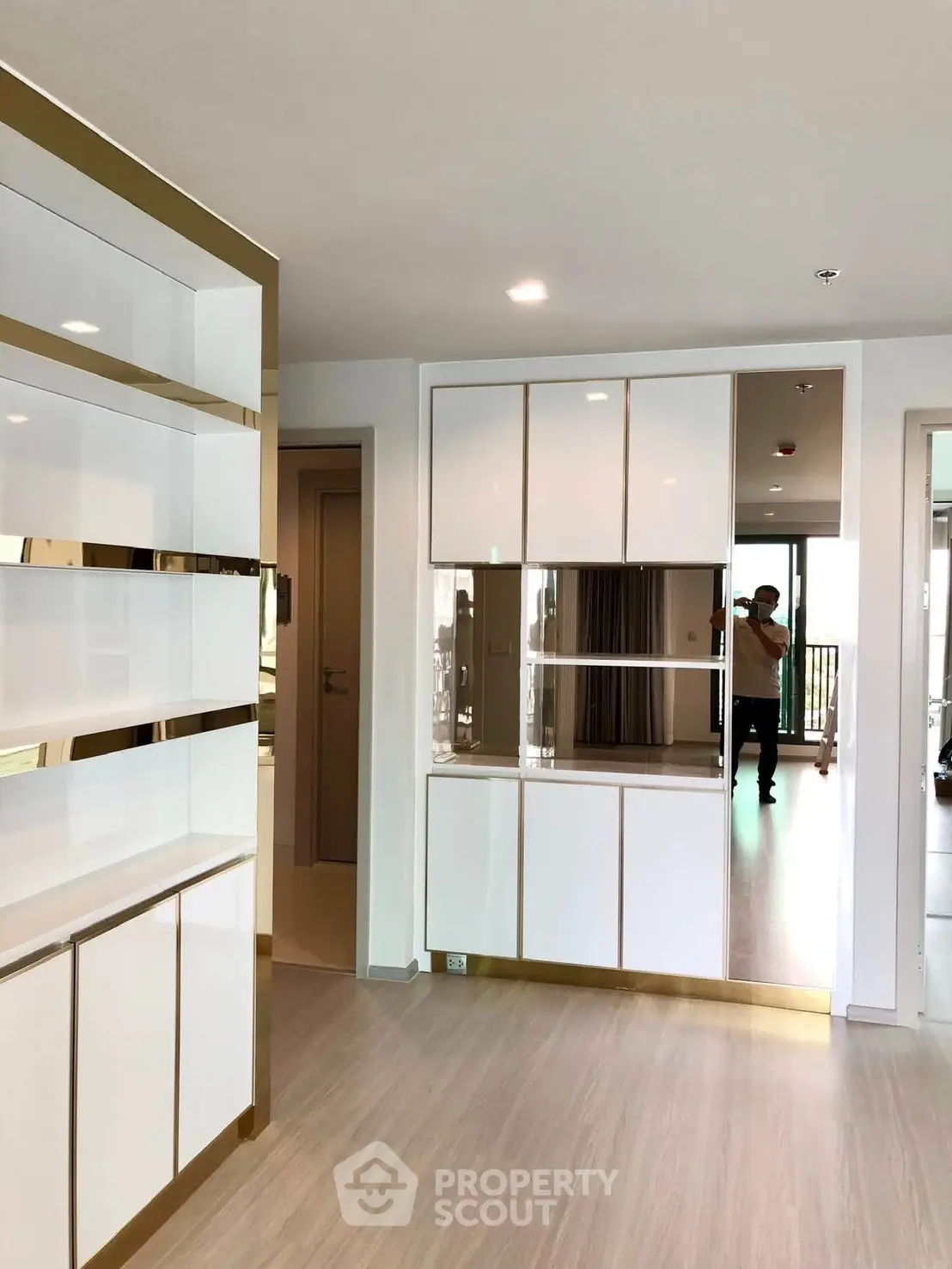 Modern apartment interior with sleek built-in storage and mirrored accents