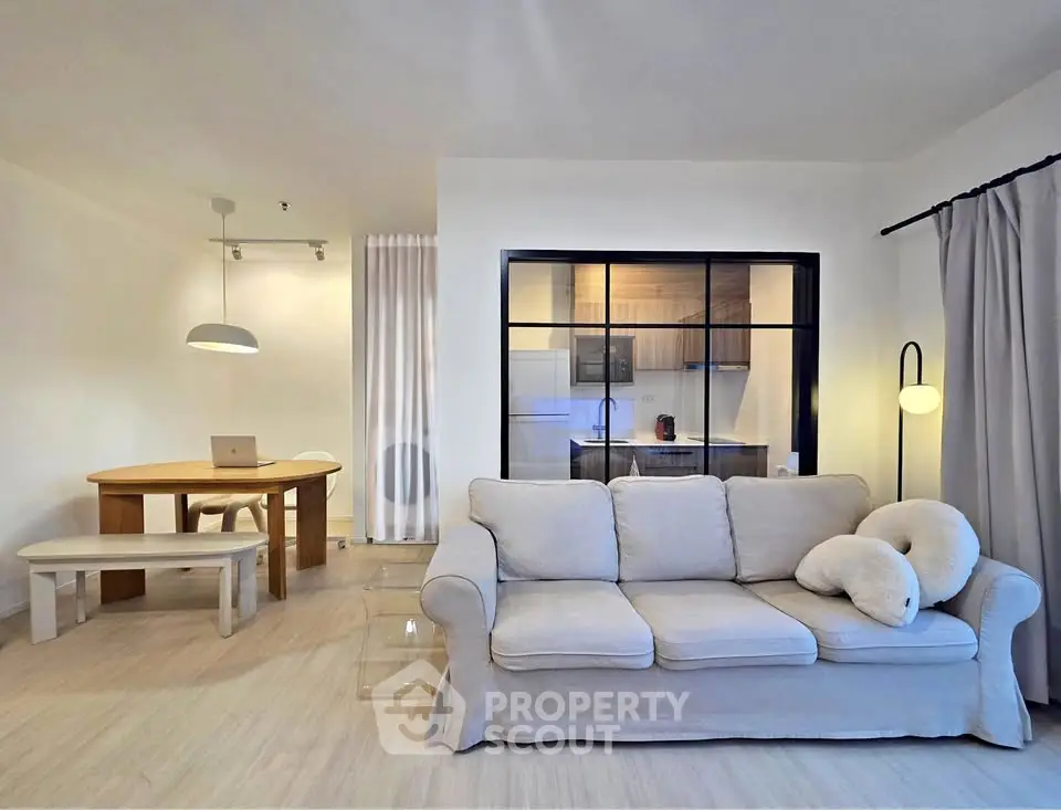 Stylish living room with cozy sofa and modern dining area in open-plan layout.