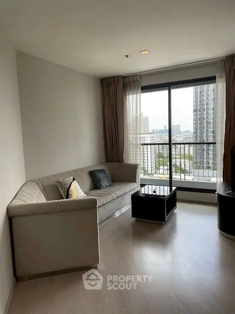 Modern living room with city view and stylish furniture in high-rise apartment.