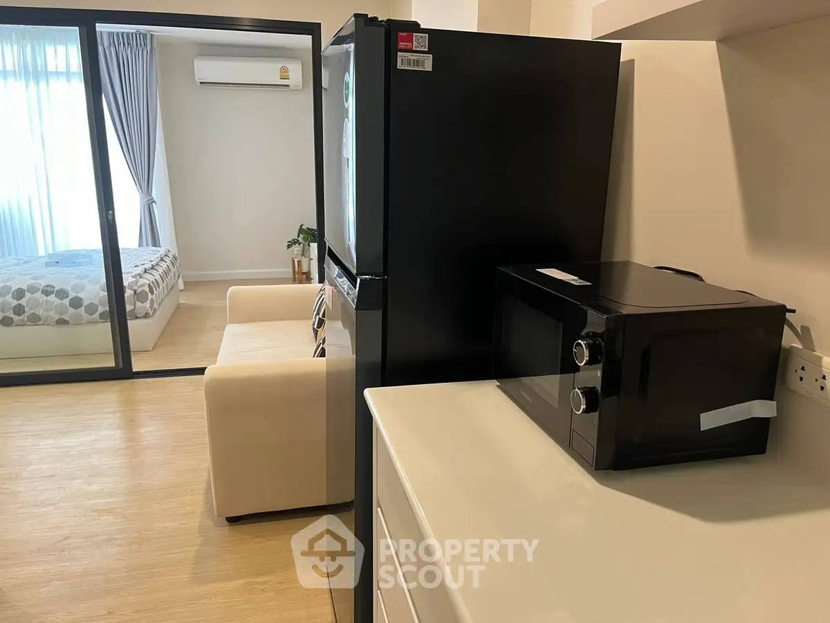 Modern apartment with sleek kitchen appliances and cozy bedroom view.