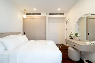 Elegant bedroom with modern decor, featuring a cozy bed and stylish vanity area.