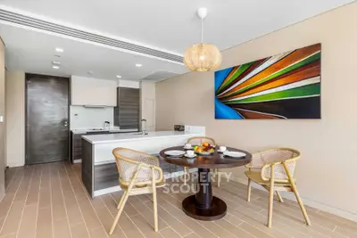 Modern kitchen with open layout and stylish dining area featuring contemporary art and elegant lighting.