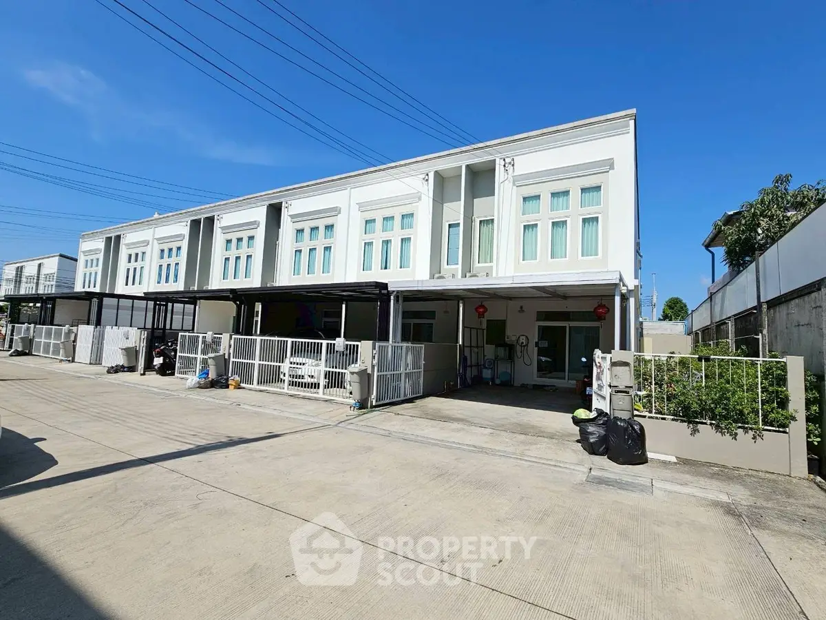 Modern townhouse exterior with clean lines and spacious driveway in a serene neighborhood.