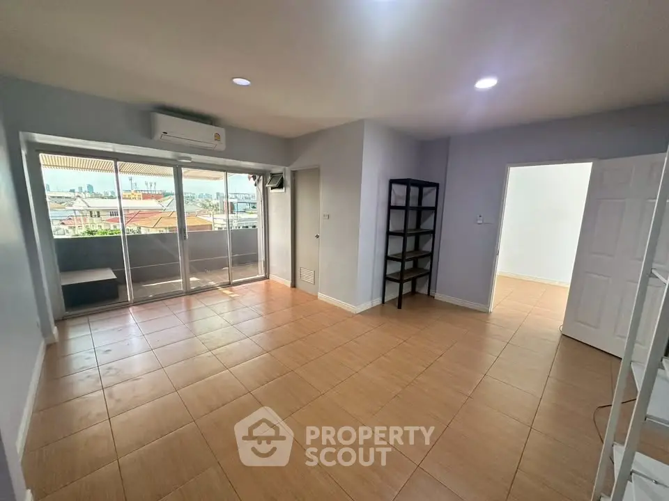 Spacious living room with balcony and city view, perfect for modern living.