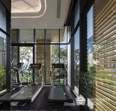 Luxurious gym with modern treadmills and floor-to-ceiling windows offering stunning views.