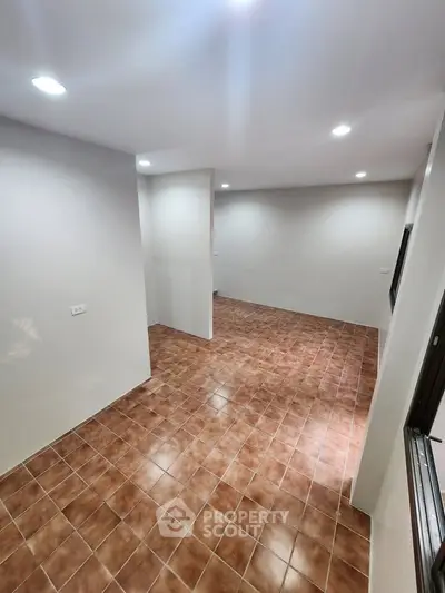 Spacious interior with tiled flooring and recessed lighting, ideal for versatile living arrangements.