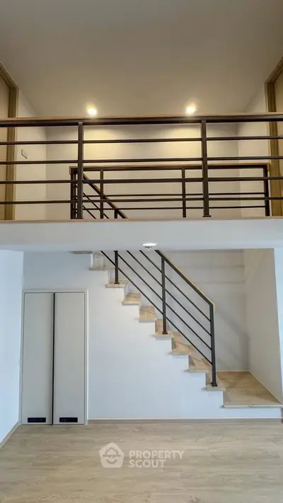 Modern duplex interior with sleek staircase and mezzanine level