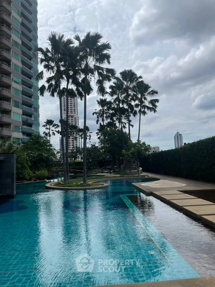 Luxurious residential pool area with palm trees and modern high-rise buildings.