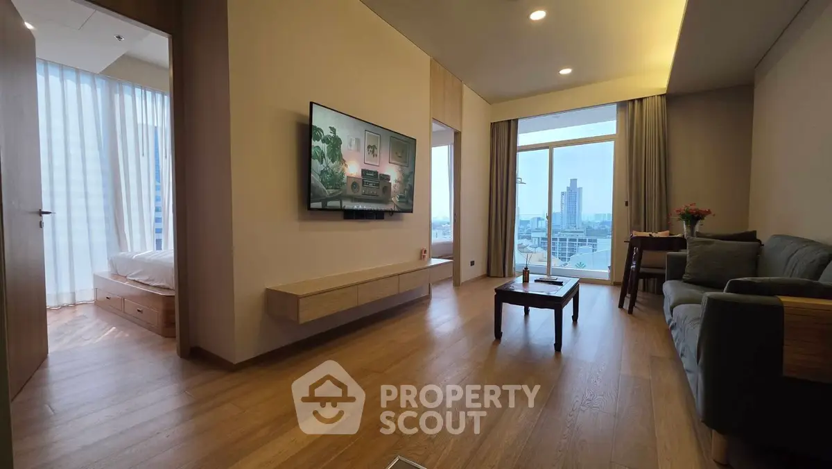 Modern living room with city view, wooden flooring, and stylish furniture in a high-rise apartment.