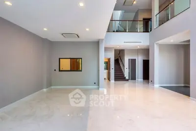 Spacious modern living room with high ceilings and elegant staircase