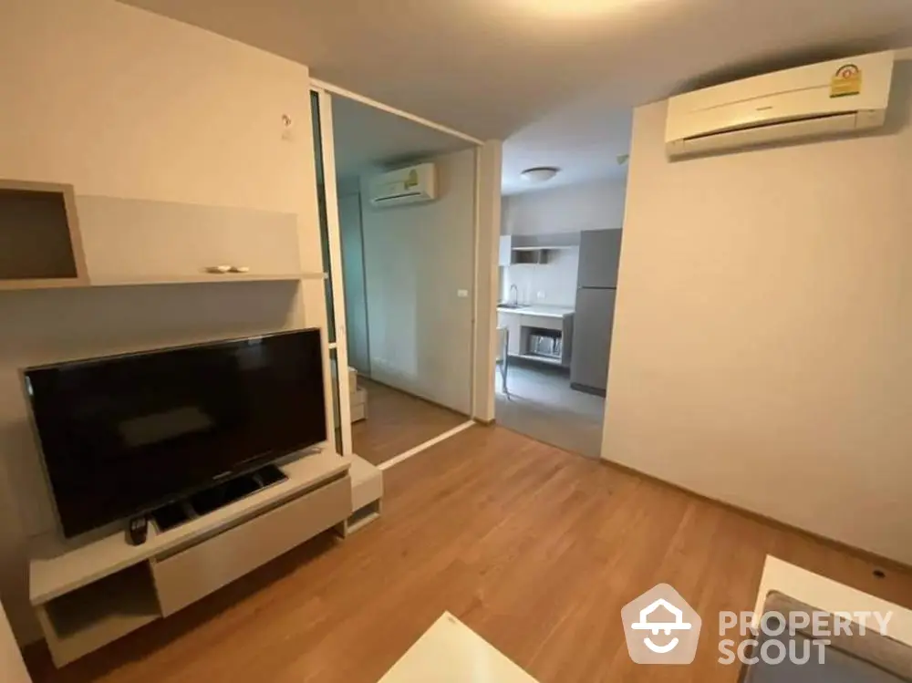 Modern living room with wooden flooring and air conditioning in a stylish apartment.