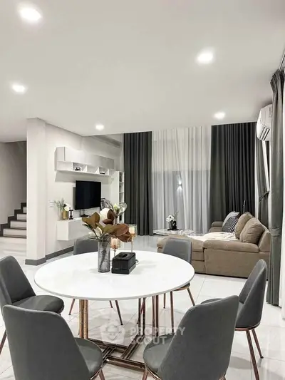 Modern living room with stylish furniture and elegant decor, featuring a cozy seating area and dining space.