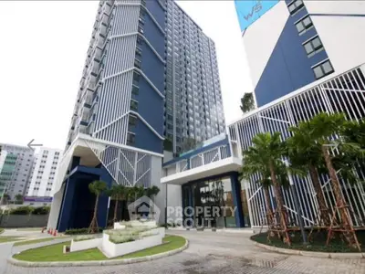 Modern high-rise building with stylish facade and landscaped entrance