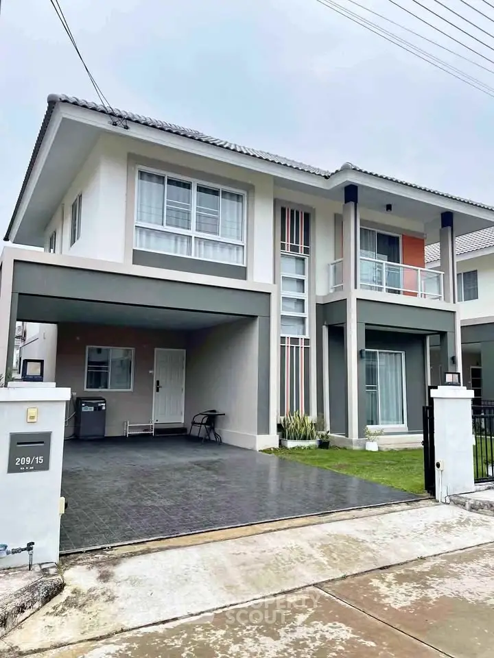 Modern two-story house with a sleek design, featuring a spacious driveway and a small garden area.