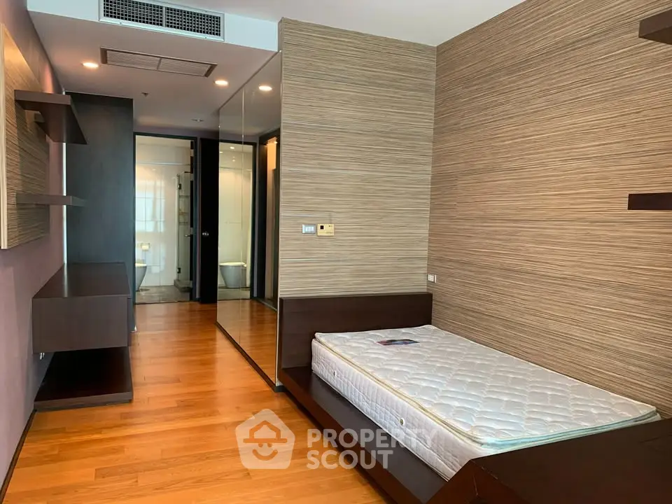 Modern bedroom with wooden flooring and stylish design in a contemporary apartment.