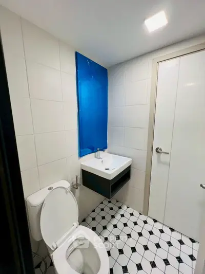 Modern bathroom with stylish black and white tile design and sleek fixtures.