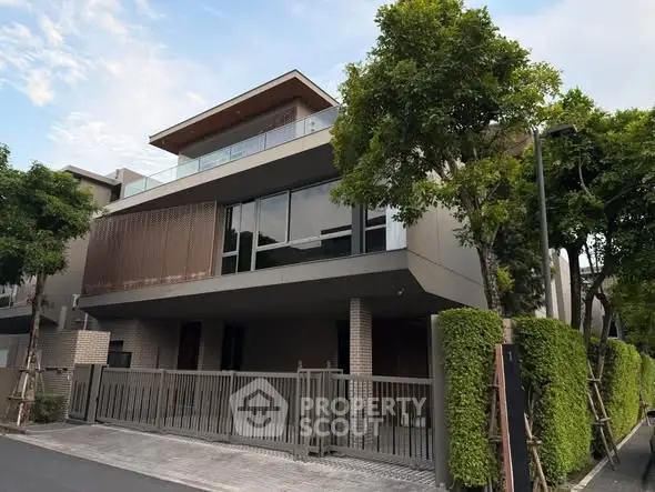 Modern luxury home with sleek design and lush greenery in an upscale neighborhood.