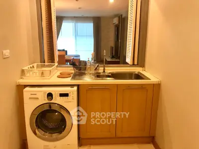 Cozy kitchen with washing machine and wooden cabinets in modern apartment