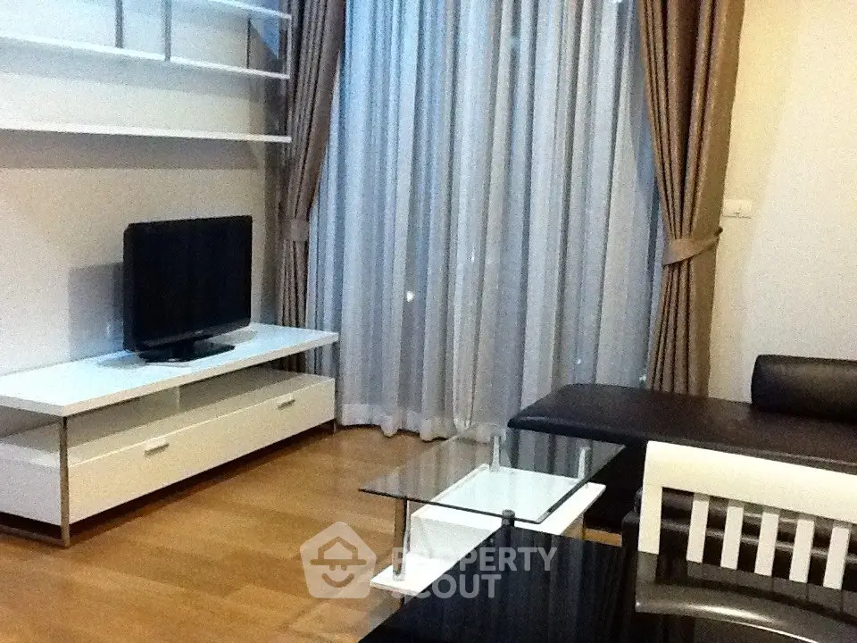 Modern living room with sleek furniture and large window drapes