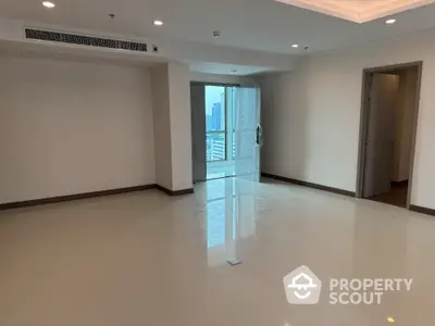 Spacious empty living room with city view and balcony access