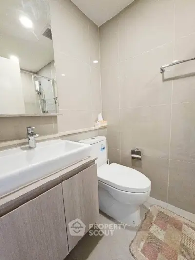 Modern bathroom with sleek fixtures and neutral tones, featuring a stylish vanity and contemporary design.