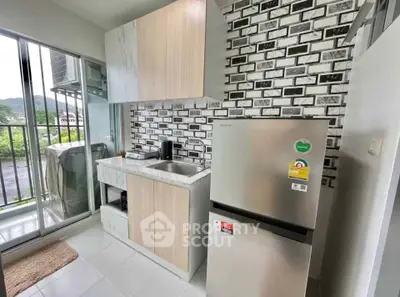 Modern kitchen with sleek cabinetry and stainless steel fridge, featuring a scenic balcony view.