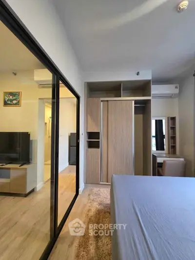 Modern bedroom with sliding glass doors and built-in wardrobe in a stylish apartment.