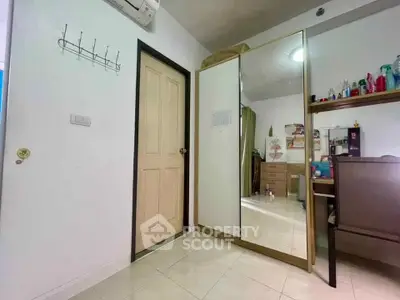 Cozy bedroom with mirrored wardrobe and desk, perfect for a comfortable living space.