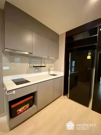 Sleek modern kitchen with built-in oven and ample cabinet space, featuring a minimalist design with clean lines and a practical layout.