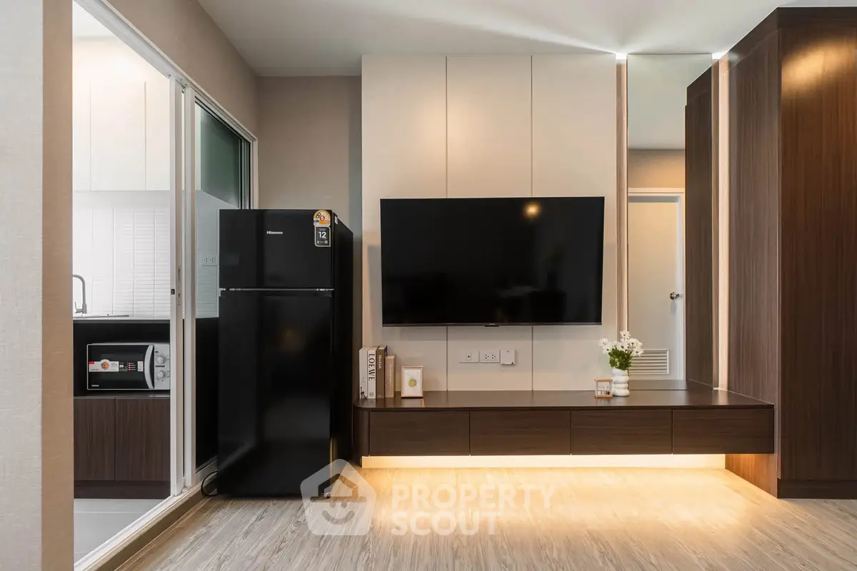 Modern living room with sleek TV setup and adjacent kitchen view