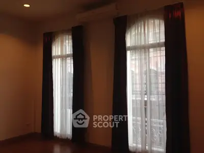 Spacious room with elegant curtains and natural light, perfect for a cozy living space.