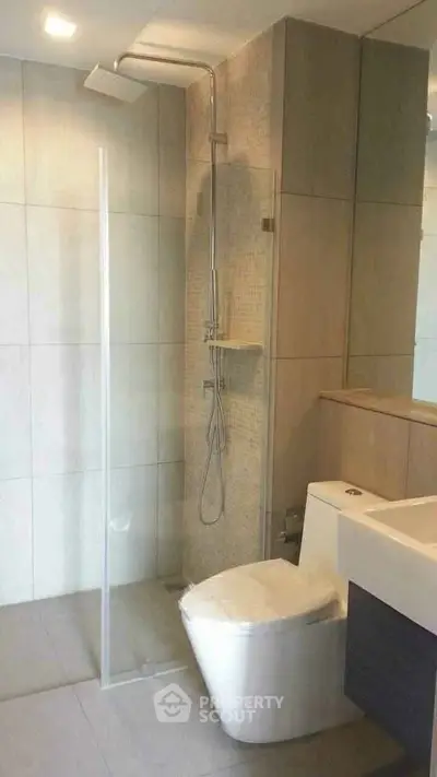 Modern bathroom with sleek shower and contemporary fixtures in a stylish real estate property.