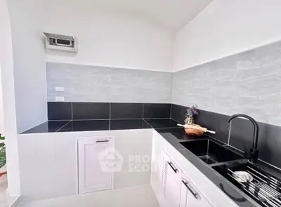 Modern kitchen with sleek black countertops and stylish fixtures